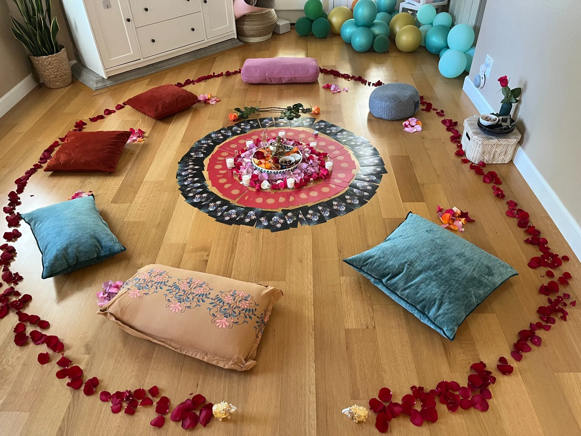 Sacred ceremony space with mandala, cushions, and rose petals arranged in a circle