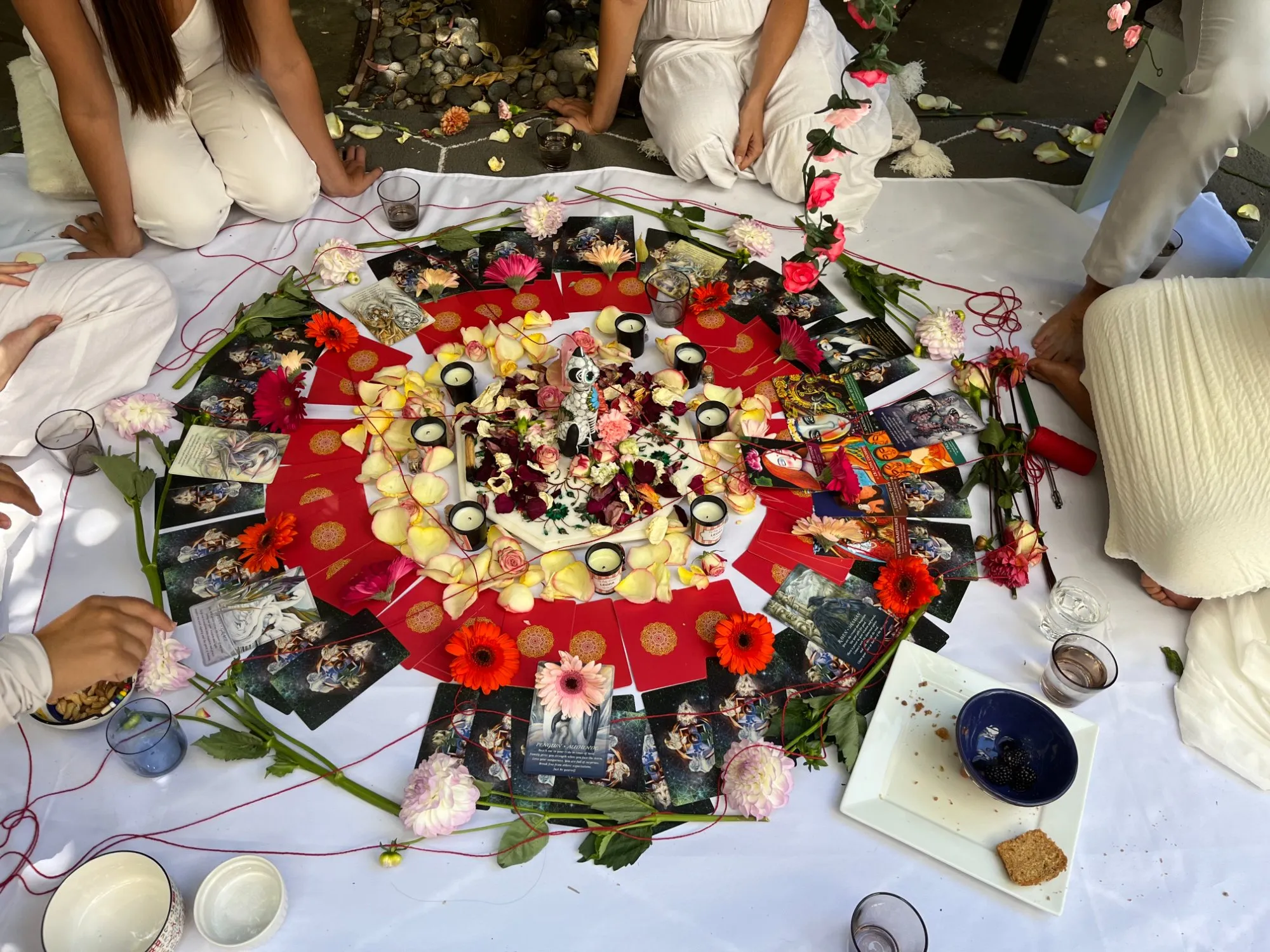 Ritual ceremony with mandala of cards, flowers, and candles